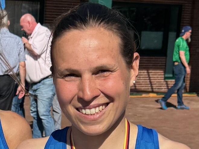 Zwei Siegerinnen in blauen Sportoberteilen halten Urkunden und Medaillen nach dem 5 km Straßenlauf.
